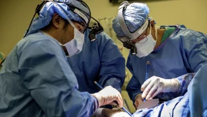 Dr Chitaru Kurihara (po lewej) i dr Ankit Bharat (po prawej) przeprowadzają operację u pacjenta, usuwając uszkodzone płuca