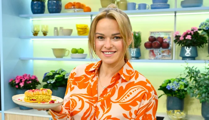 Karolina Stolarska-Bigos z talerzem, na którym leży eklerka