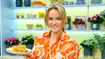 Karolina Stolarska-Bigos z talerzem, na którym leży eklerka