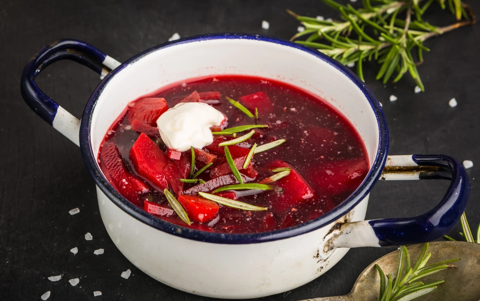 Czerwony barszcz z kleksem śmietany w garnku