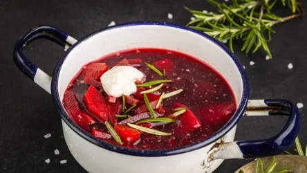 Czerwony barszcz z kleksem śmietany w garnku