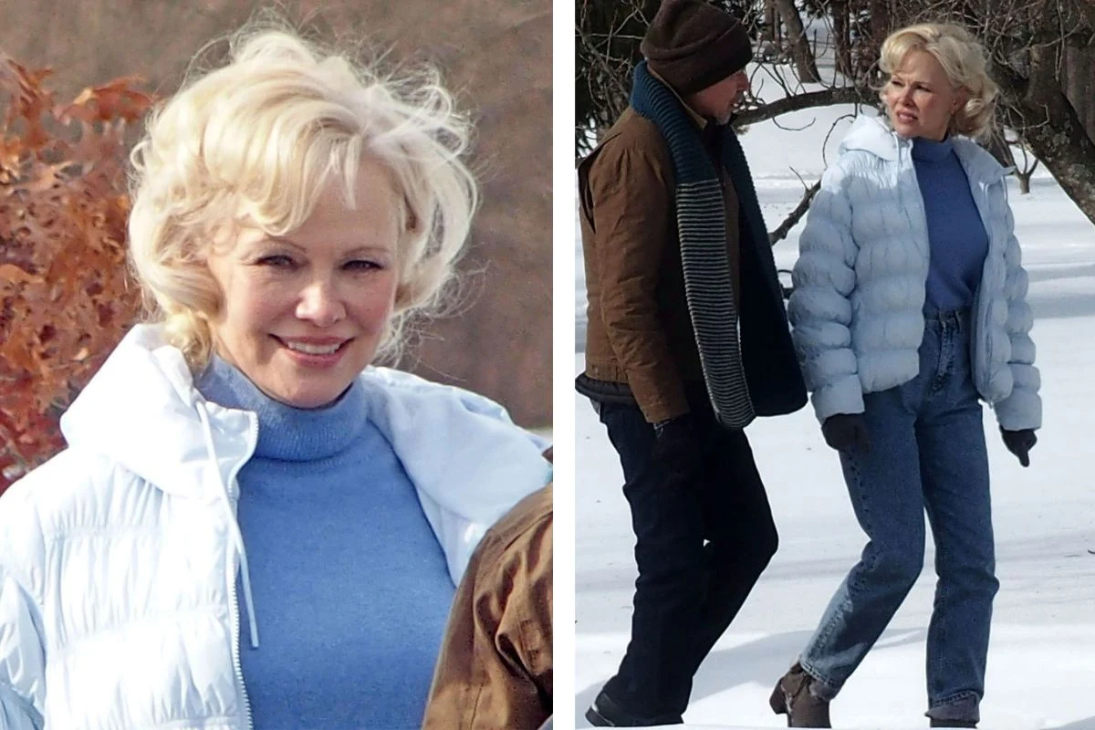 Pamela Anderson nosi mroźny błękit Kobieta o blond włosach ubrana w jasnoniebieską kurtkę puchową i niebieski golf, spaceruje po zaśnieżonym terenie w towarzystwie mężczyzny w ciemnej kurtce, szaliku i czapce. W tle gołe gałęzie drzew.