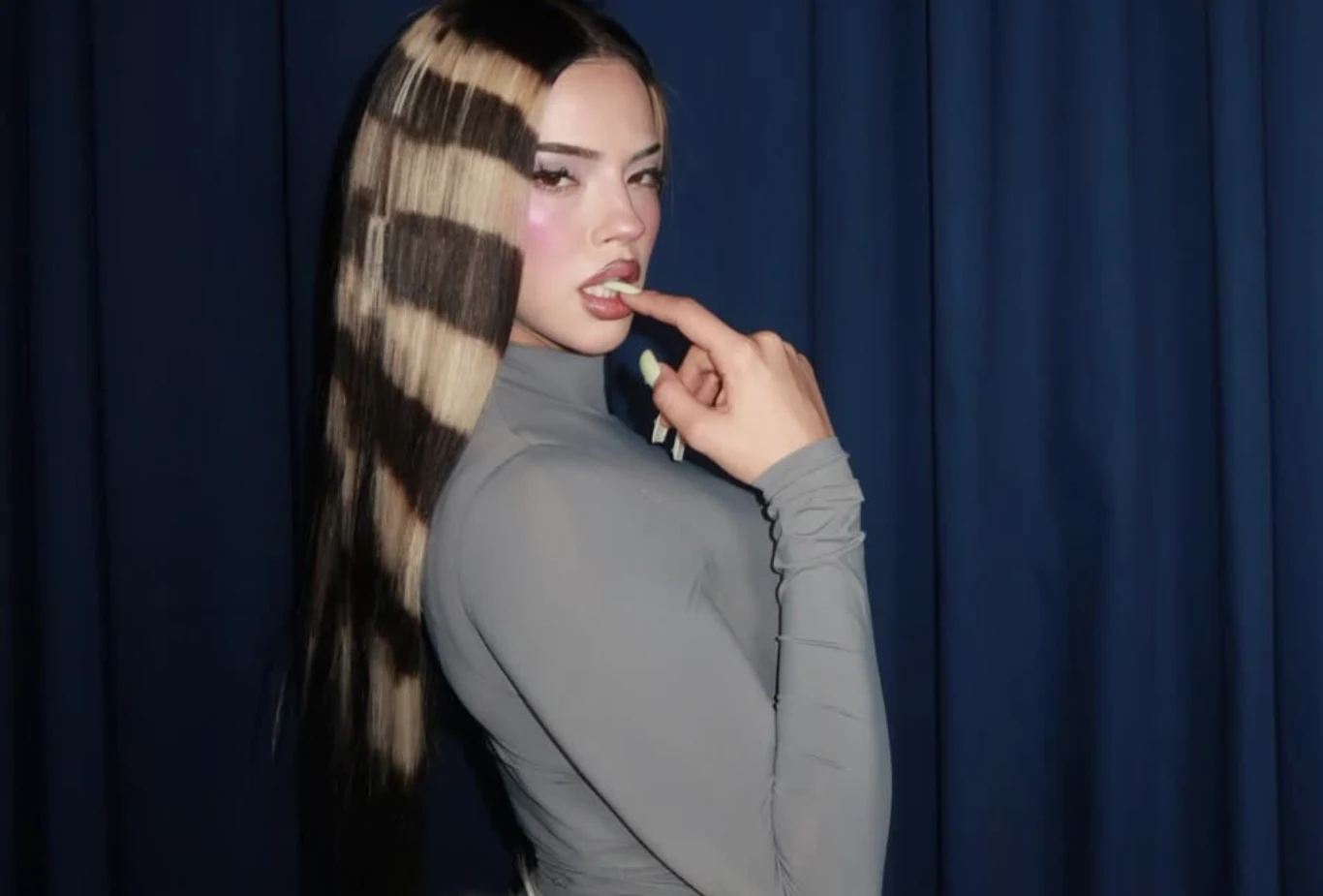 Dara została wybrana jako reprezentantka Bułgarii w Konkursie Eurowizji Młoda kobieta w szarym body z długimi, ciemnymi włosami ozdobionymi szerokimi, jasnymi pasmami pozuje na tle granatowej zasłony, z palcem dotykającym ust i makijażem podkreślającym policzki.