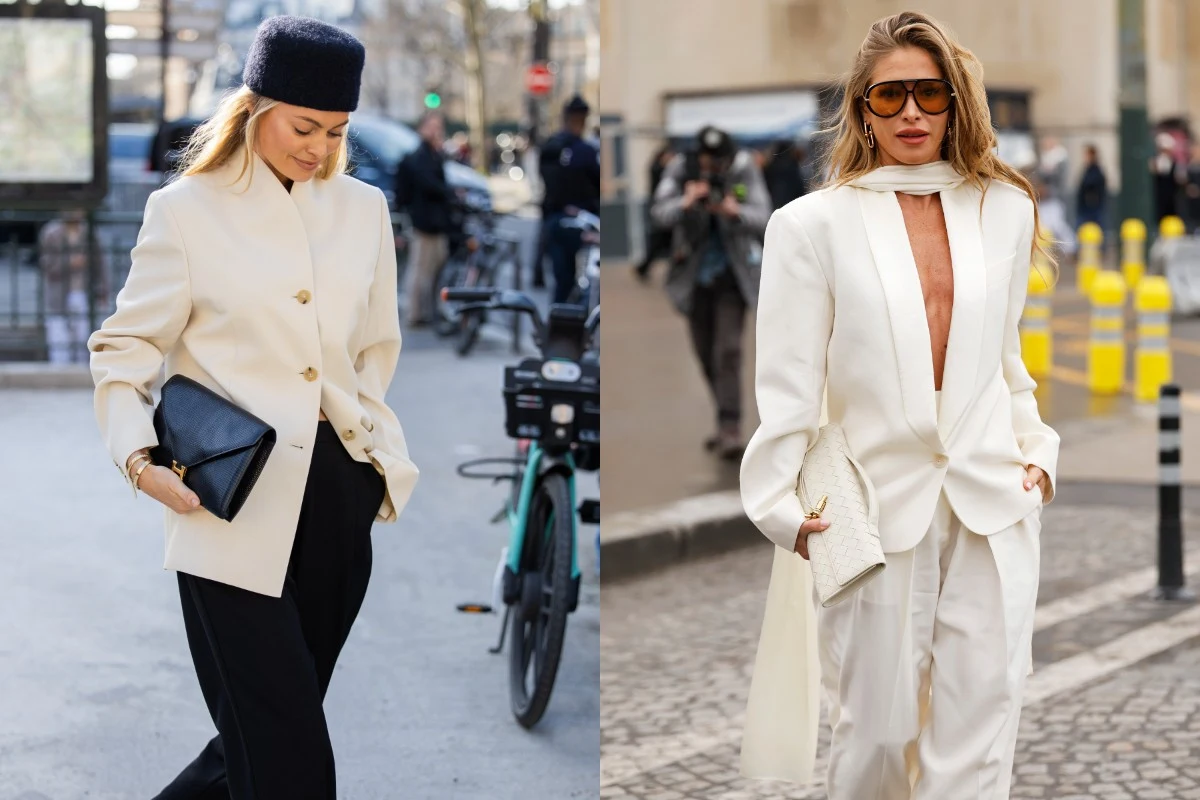 Ten modowy trend jest odpowiedzią na przebodźcowanie. Fot. Christian Vierig, Claudio Lavenia Dwie kobiety w eleganckich, jasnych marynarkach, ubrane w stylu miejskim. Jedna z nich trzyma czarną kopertówkę i nosi granatową czapkę, druga ma długie, rozpuszczone włosy, duże okulary przeciwsłoneczne oraz białą torebkę.