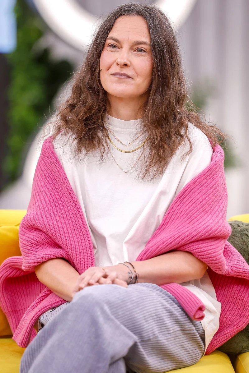 Małgorzata Bursztynowicz do prostego zestawu dodała intensywnie różowy sweter. To świetny pomysł na ożywienie looku i komfort, gdy na dworze jest zimno