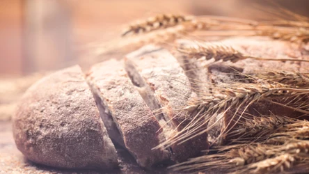 Wiejski chleb i pszenica na drewnianym stole