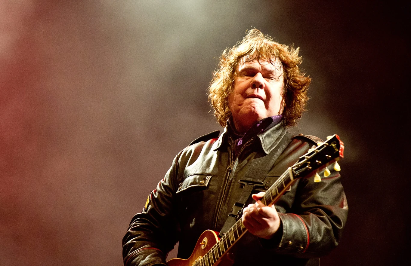 Gary Moore na jednym ze swoich ostatnich koncertów - Sweden Rock Festival, 11 czerwca 2010 r. Mężczyzna grający na gitarze elektrycznej w skórzanej kurtce, intensywne światło sceniczne w tle, silnie skupiony wyraz twarzy muzyka.