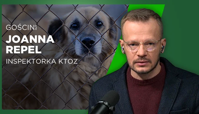 Mężczyzna w okularach siedzi przed mikrofonem, w tle widoczny duży pies za ogrodzeniem z siatki oraz tekst informujący o gościni Joannie Repel, inspektorce KTOZ.