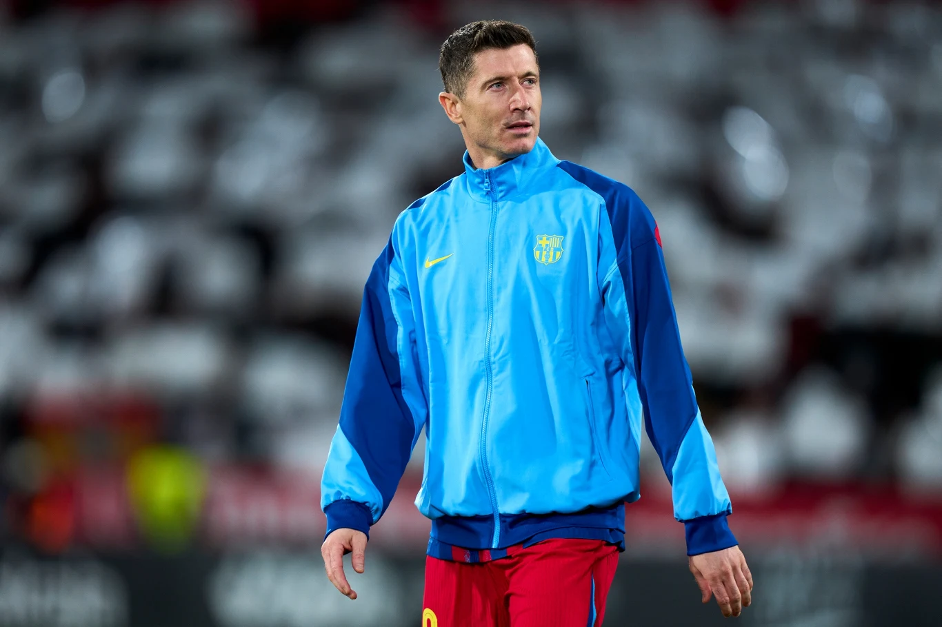 Oficjalny komunikat. FC Barcelona wycofuje się z historycznego projektu. Lewandowski już wie Piłkarz w niebieskiej kurtce treningowej klubu FC Barcelona stoi na murawie stadionu, w tle rozmazane trybuny i boisko