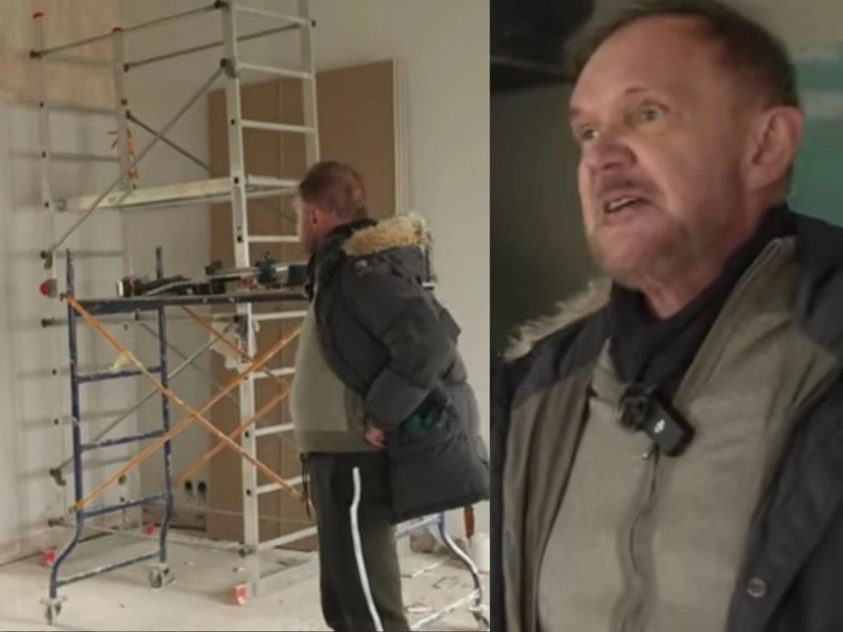 Dwie osoby w kurtkach zimowych znajdują się we wnętrzu remontowanego pomieszczenia, w tle widoczne rusztowanie budowlane oraz materiały budowlane rozmieszczone na podłodze.