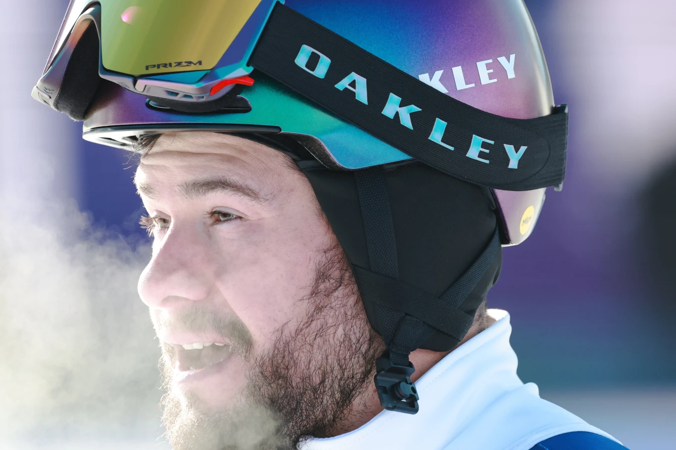 Oskar Kwiatkowski Narciarz w kasku i goglach marki Oakley, z widoczną parą wydobywającą się z ust w mroźnym powietrzu.