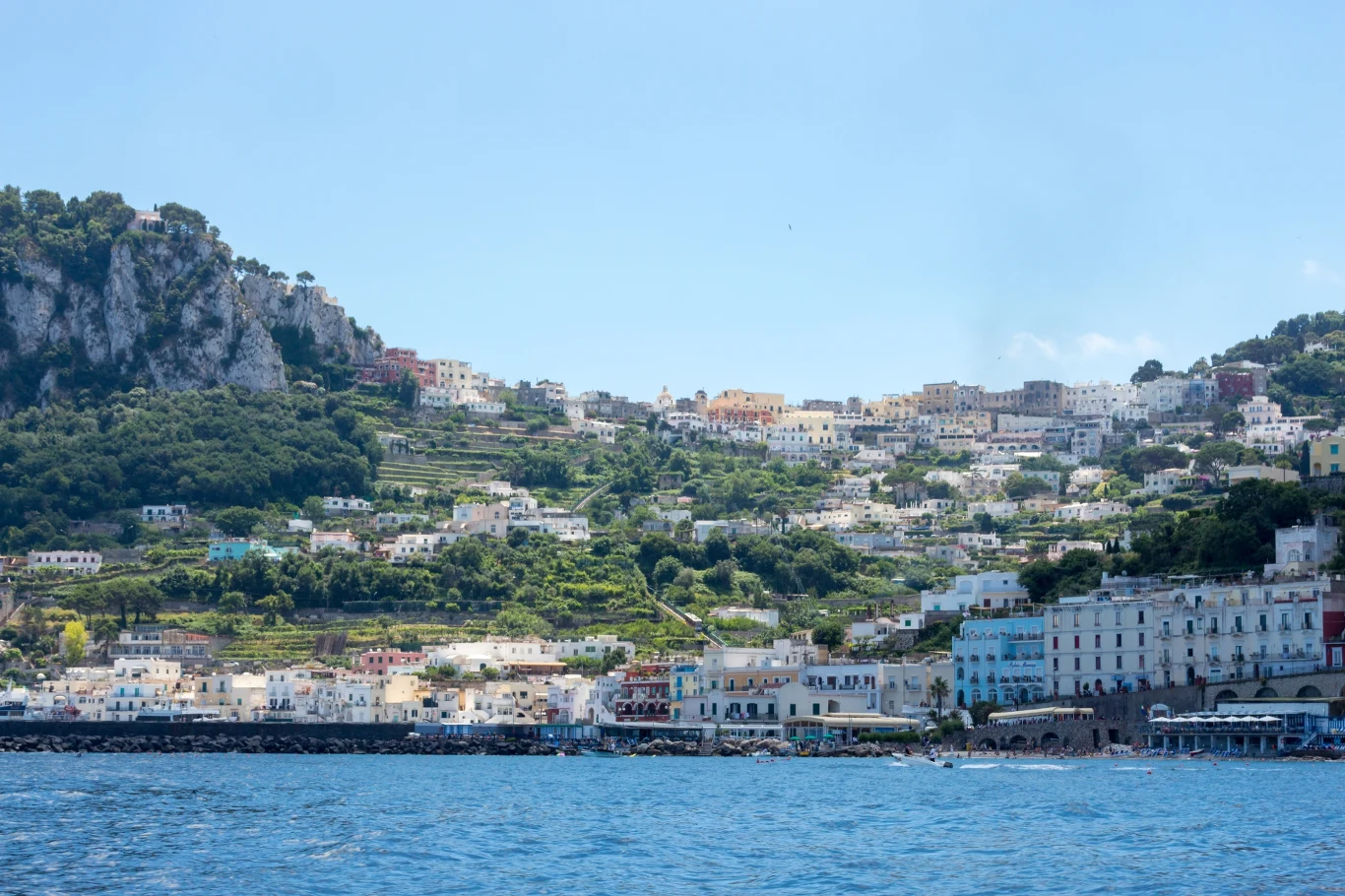 Władze i mieszkańcy Capri narzekają na zbyt dużą liczbę turystów na wyspie Kolorowe domy rozsiane na wzgórzu, położone nad lazurową wodą, z bujną zielenią otaczającą zabudowania oraz malowniczymi tarasami na tle skalistego krajobrazu.