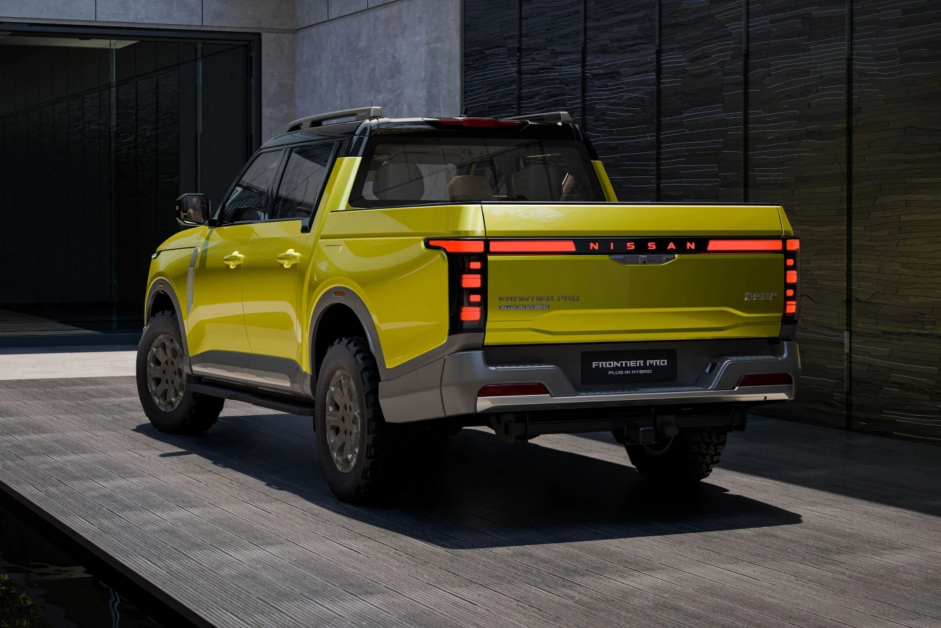 Jasnożółty pickup Nissan Frontier Pro z nowoczesnymi, pionowymi tylnymi światłami, szeroką kabiną i masywnymi oponami terenowymi stoi na podjeździe obok budynku o betonowych ścianach.