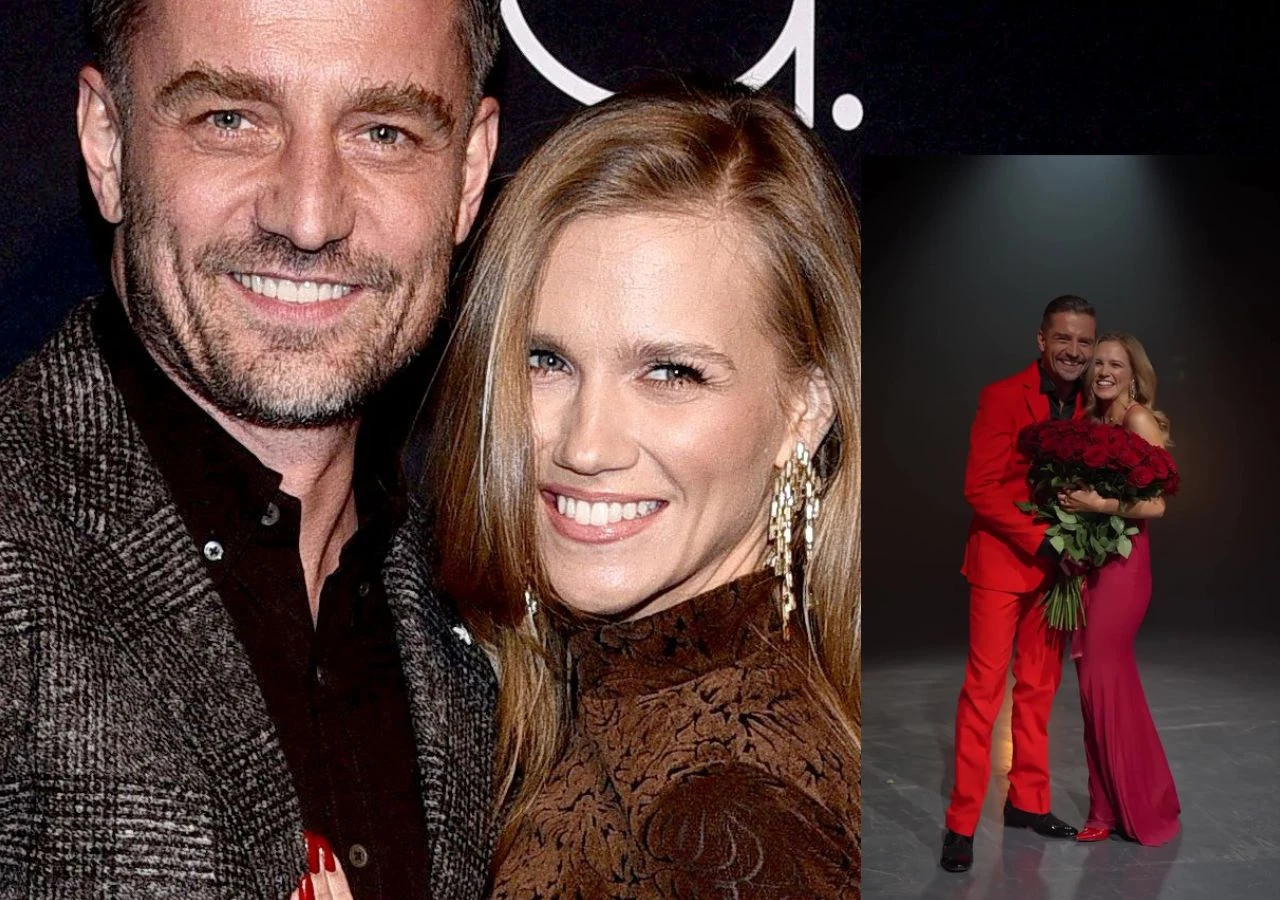 Uśmiechnięta para obejmująca się podczas wydarzenia wieczorowego, kobieta trzyma bukiet czerwonych róż, oboje ubrani elegancko, mężczyzna w czerwonym garniturze, kobieta w różowej sukni, tło neutralne.