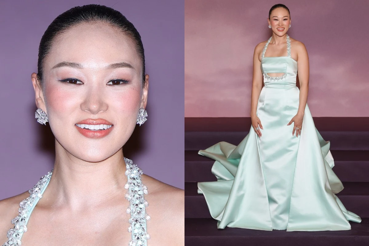 Makijaż na walentynki Uśmiechnięta kobieta w eleganckiej, jasnozielonej sukni wieczorowej z bogato zdobionym dekoltem, długim trenem i biżuterią w postaci kolczyków oraz ozdób na ramiączkach, stoi przed pastelowym, różowo-fioletowym tłem.