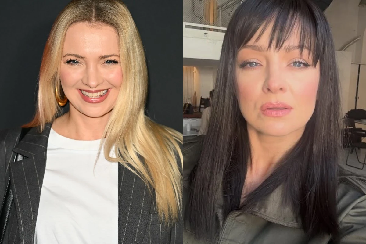 Dwie kobiety pozujące, jedna o blond włosach uśmiecha się do obiektywu, druga o ciemnych włosach ma poważny wyraz twarzy, w tle wnętrze pomieszczenia.