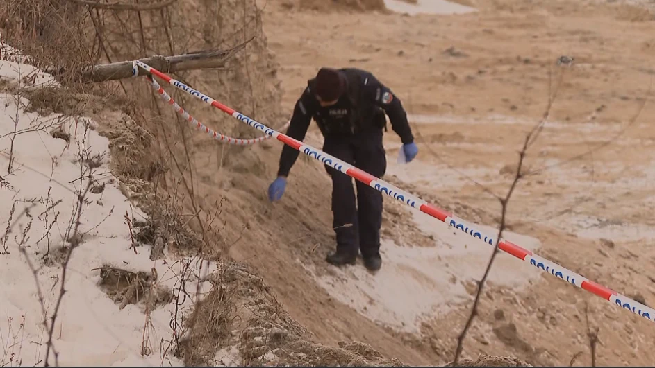 W żwirowni nieopodal Buska-Zdroju policja znalazła szczątki, trwa ustalanie okoliczności Policjant w rękawiczkach ochronnych idzie po piaszczystym, wyznaczonym taśmą terenie, najprawdopodobniej prowadząc czynności śledcze lub zabezpieczając miejsce zdarzenia.
