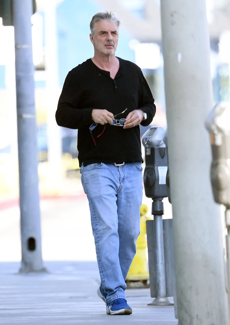 Chris Noth w czarnej bluzie do bioder i jasnoniebieskich dżinsach