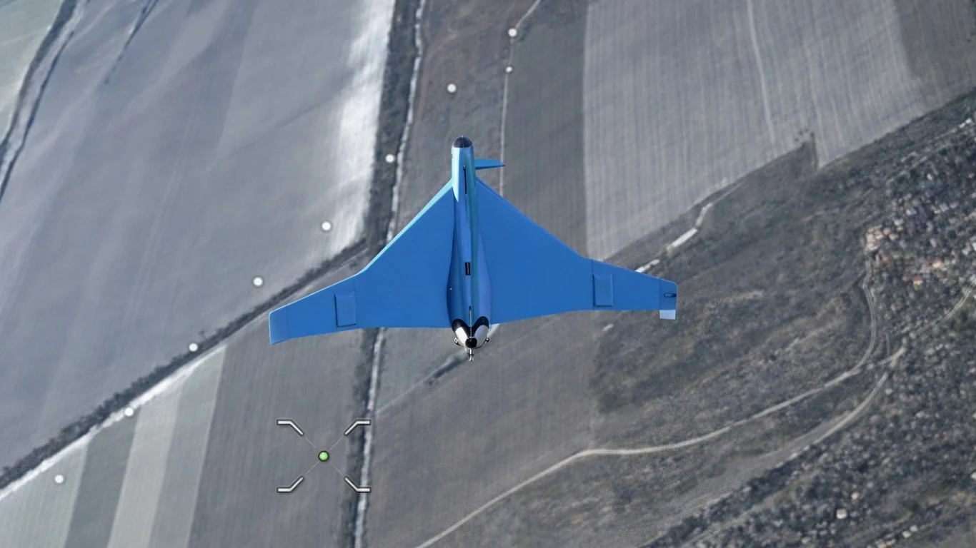 Ukraińcy strącili najnowszy rosyjski dron typu "Klin" Samolot bezzałogowy w locie nad rozległymi, podzielonymi polami, widok z góry na krajobraz rolniczy przecięty drogą i pojedynczymi liniami drzew.