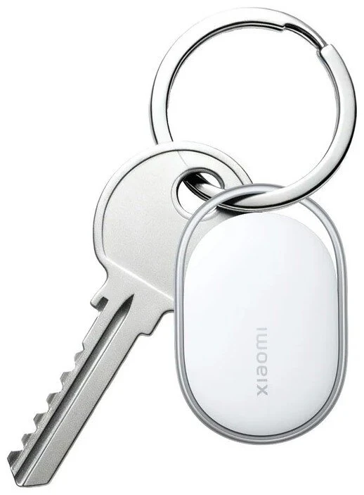 Lokalizator Xiaomi Tag. Metalowy klucz zawieszony na srebrnym kółku do kluczy wraz z brelokiem Xiaomi w kolorze białym o opływowym kształcie.