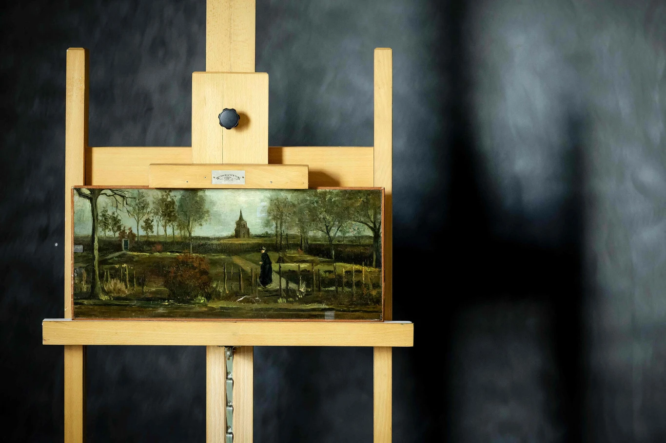 Skradziony obraz Vincenta van Gogha odnalazł się po latach. To zasługa holenderskiego detektywa Sztaluga drewniana z zamocowanym obrazem przedstawiającym wiejski krajobraz z alejką, drzewami oraz postacią ubraną na czarno, na tle rozmytej, ciemnej ściany.