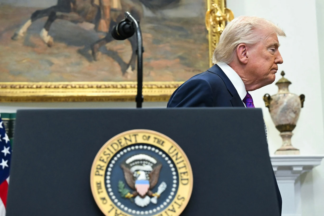 Trump planuje znieść część ceł na wyroby ze stali i aluminium - donosi "Financial Times" Donald Trump wychodzi zza mównicy z emblematem prezydenta Stanów Zjednoczonych, w tle widoczny fragment obrazu i elegancka urna.