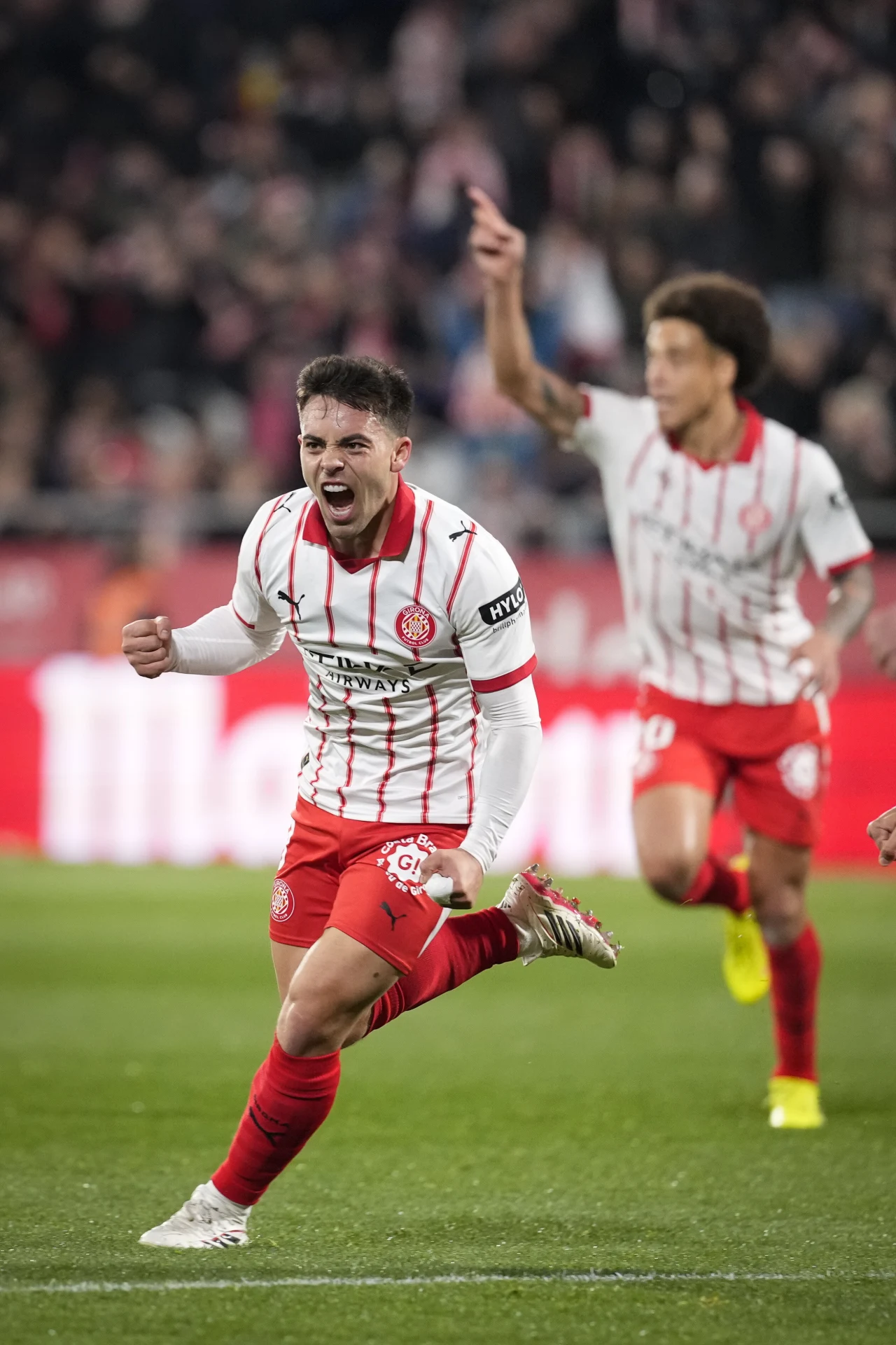 Fran Beltran, autor zwycięskiej bramki dla gospodarzy Piłkarz w czerwono-białym stroju biegnie z radością po murawie, świętując prawdopodobnie zdobycie gola, w tle inny piłkarz z uniesioną ręką i rozmazana publiczność na trybunach.