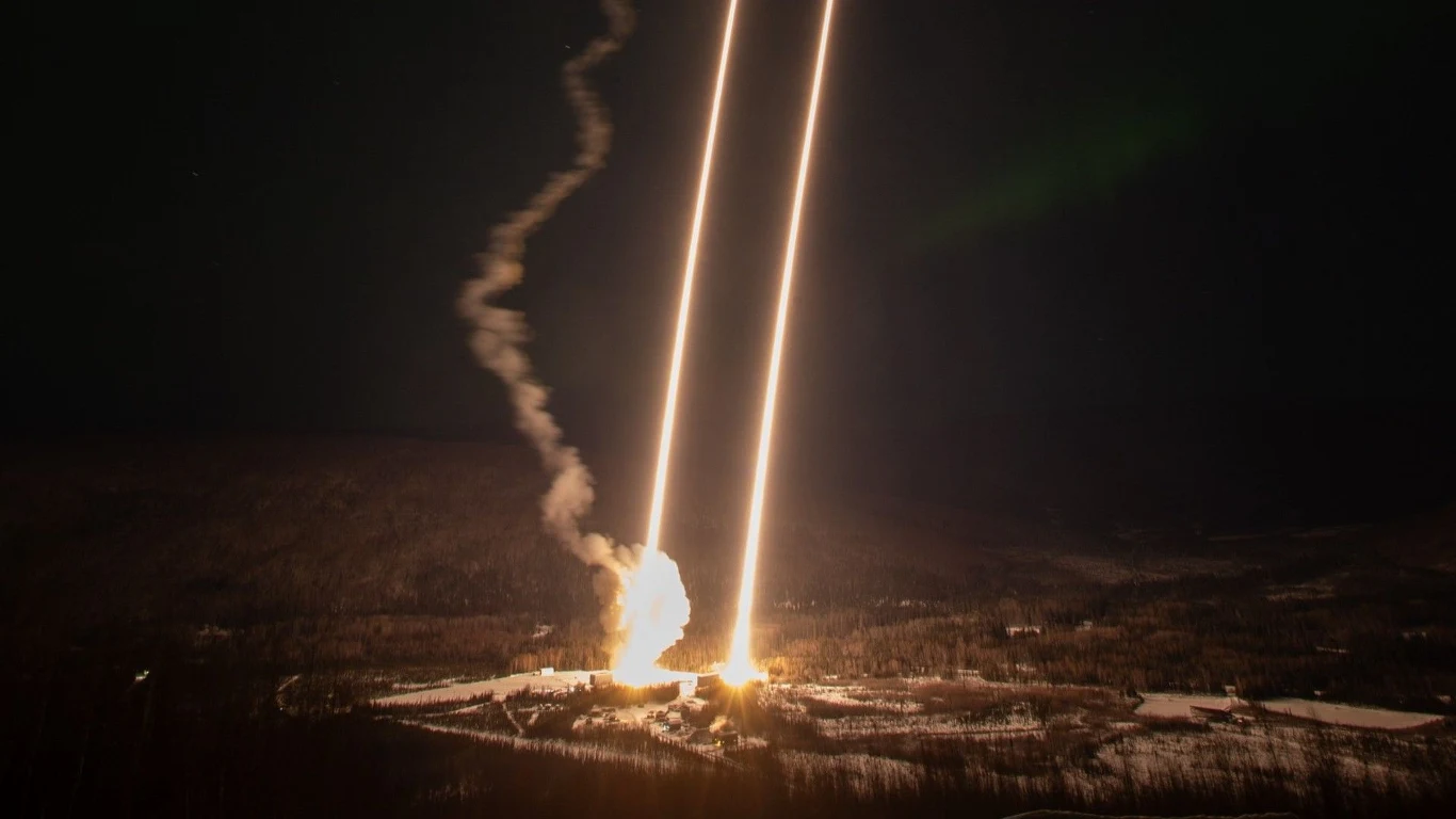 NASA wystrzeliła dwie rakiety z Alaski. Celem misji tajemnicze zorze polarne. Jasne smugi światła unoszące się pionowo w górę na tle nocnego, ciemnego nieba, wystrzeliwane z powierzchni ziemi przy stosunkowo małym rozbłysku i dymie, otoczone leśnym, zaśnieżonym krajobrazem.