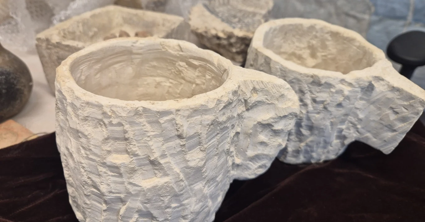 Złodzieje wykopali historię. Na Górze Skopus odkryto warsztat z czasów Drugiej Świątyni Kamienne naczynia o surowo obrobionej powierzchni, ustawione na ciemnym materiale, w tle widoczne inne przedmioty z podobnego materiału.