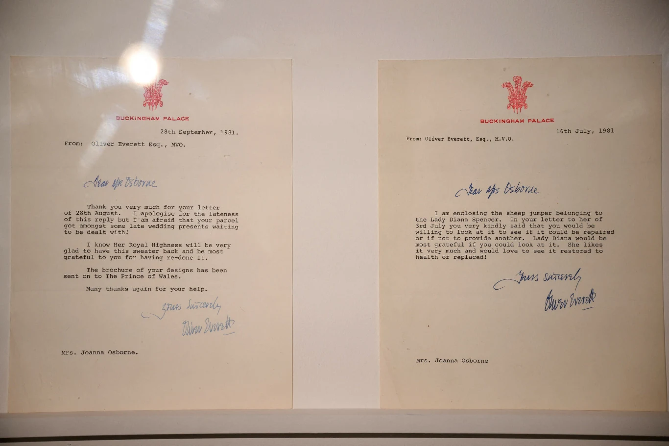 Dwa oficjalne listy na papierze listowym z czerwonym herbem, napisane na maszynie, podpisane odręcznie niebieskim atramentem, skierowane do tej samej adresatki, umieszczone obok siebie w ramie.