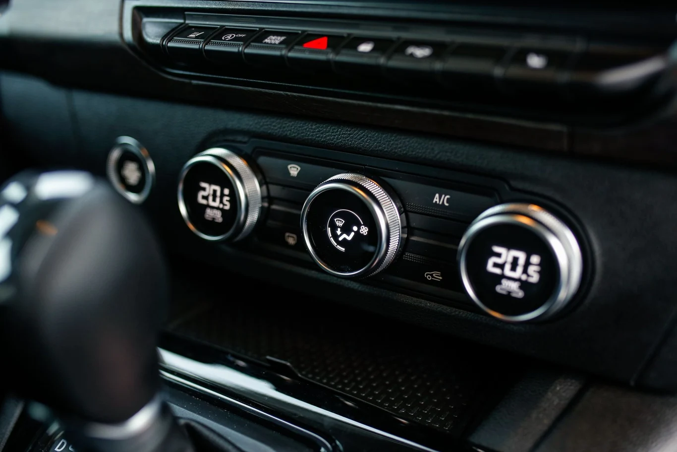 Cieszy obecność dużych pokręteł do regulowania klimatyzacji. Panel sterowania klimatyzacją w samochodzie z trzema pokrętłami ustawionymi na temperaturę 20,5°C, przyciskami funkcyjnymi i wyświetlaczami cyfrowymi.