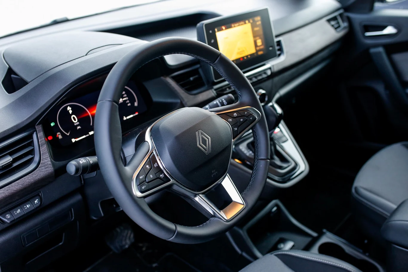 Wewnątrz Renault Grand Kangoo nie brakuje różnych schowków. Łącznie to 58 litrów. Wnętrze samochodu z nowoczesną deską rozdzielczą, cyfrowym wyświetlaczem zegarów, centralnym ekranem multimedialnym oraz kierownicą z logo marki Renault.