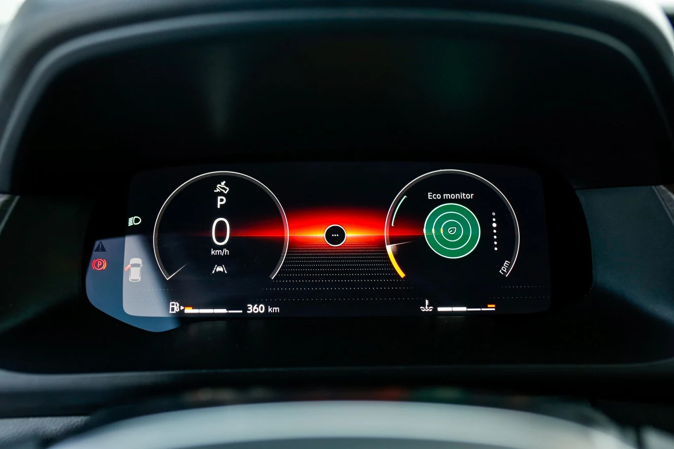 Wyświetlacz wskaźników oferuje różne tryby układu: z okrągłymi tarczami (choć bez cyfr) lub z wyszczególnieniem systemów bezpieczeństwa. Cyfrowy panel multimedialny samochodu prezentujący informacje o prędkości, trybie jazdy, stanie paliwa, ustawieniach ekologicznym oraz ostrzeżeniach systemu pojazdu.
