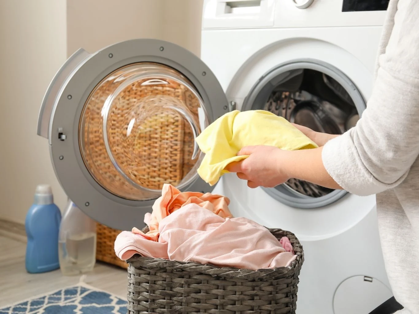 Przy każdym praniu ustaw odpowiednią prędkość wirowania Osoba wkładająca kolorowe ubrania do bębna pralki automatycznej.