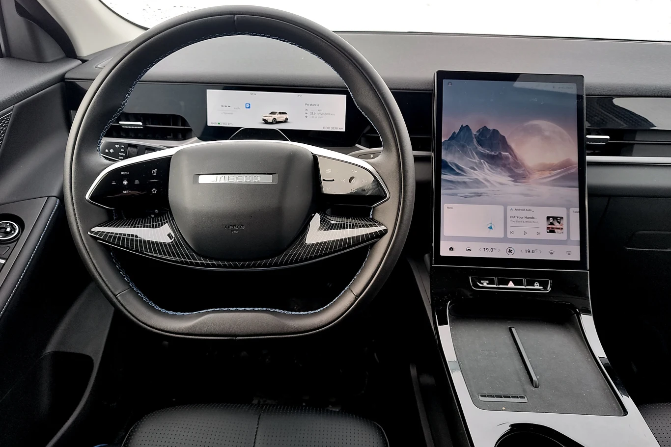 W Jaecoo E5 włączenie ogrzewania kierownicy i fotela jest na tyle skomplikowane, że może się aktywować system ostrzegania o rozproszeniu kierowcy Nowoczesna kierownica wykonana z materiału imitującego karbon, duży ekran dotykowy na konsoli centralnej, minimalistyczny panel sterowania, elektroniczny zestaw wskaźników i widoczne systemy multimedialne.