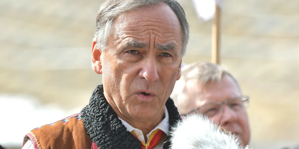 "Król Podhala" buduje termy w Zakopanem. Obiekt jest warty pół miliarda złotych Starszy mężczyzna w tradycyjnym stroju mówi do mikrofonu, w tle widoczna zamazana postać innego mężczyzny.