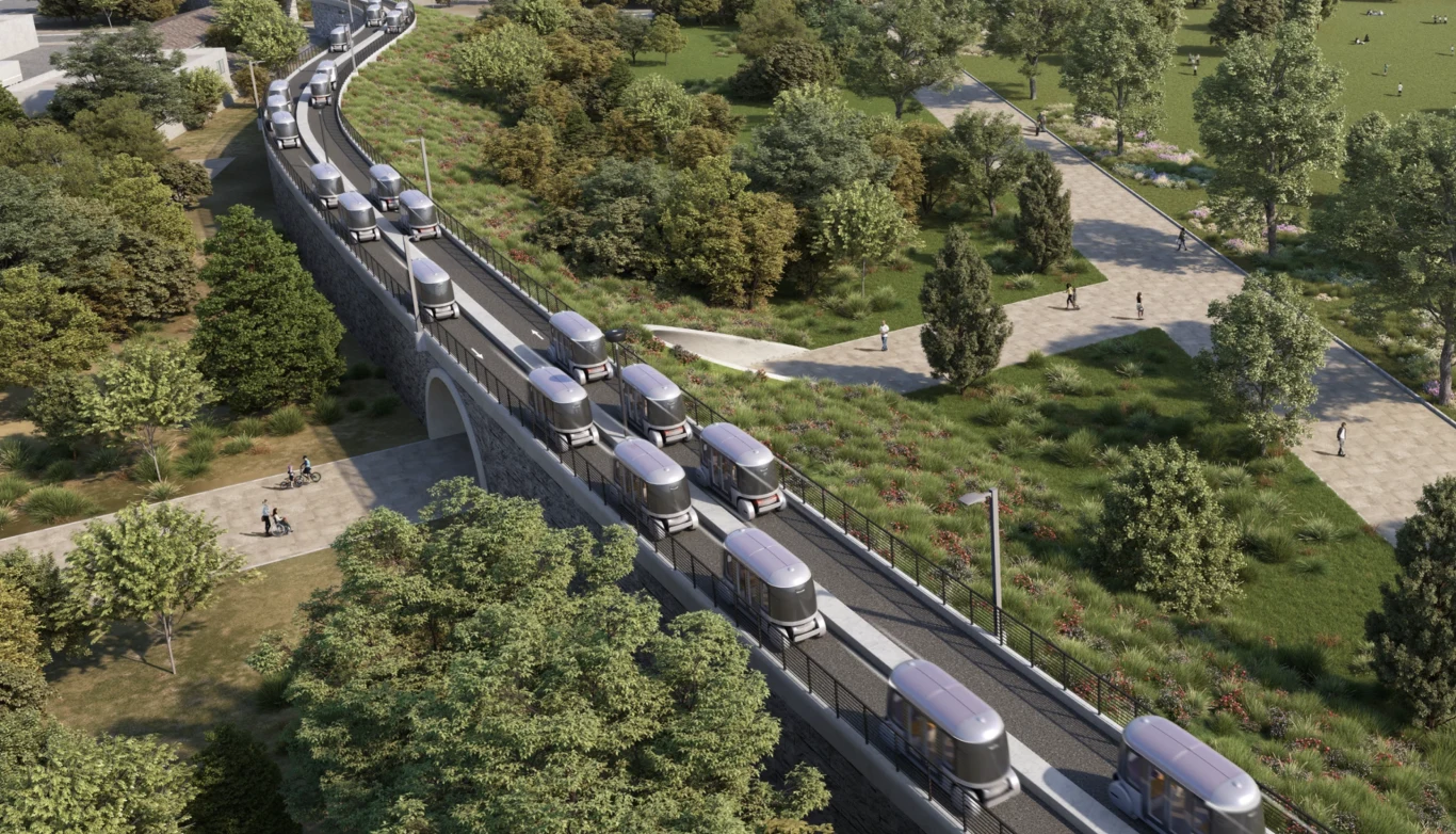 Szybko, tanio i bez korków. Tak ma wyglądać sieć transportowa przyszłości Automated Transit Network firmy Glydways Nowoczesna linia transportu publicznego złożona z wielu autonomicznych wagoników poruszających się po wyznaczonej trasie przez park, otoczona gęstą zielenią, z widocznymi alejkami spacerowymi oraz ludźmi korzystającymi z przestrzeni rekreacyjnej.