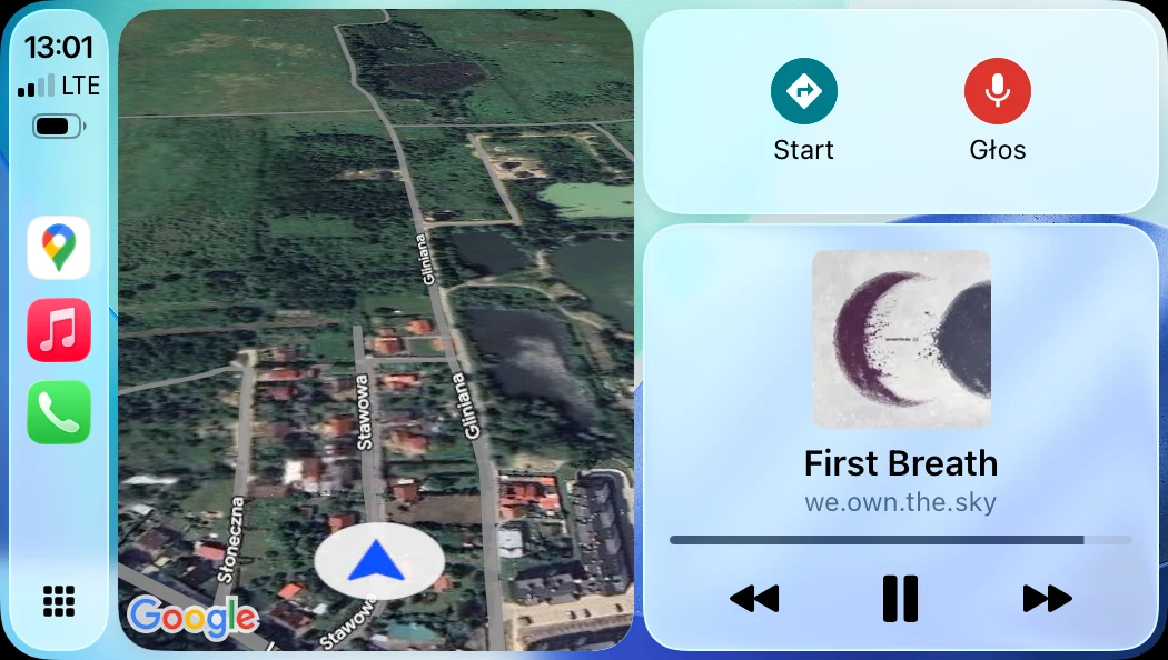 Widok satelitarny obszaru z wyraźnie widocznymi ulicami i budynkami w otoczeniu zieleni, obok panel sterowania z opcją nawigacji głosowej oraz odtwarzaczem muzycznym z okładką albumu i tytułem utworu.