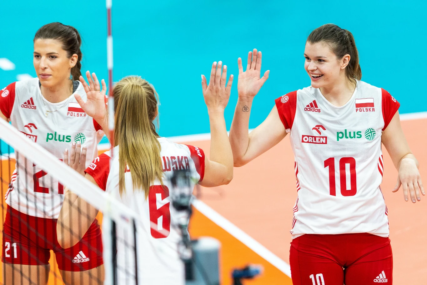 Monika Lampkowska (nr 10) w poprzednim sezonie nie została powołana do reprezentacji Polski Siatkarki polskiej reprezentacji w biało-czerwonych strojach celebrują punkt podczas meczu, przybijając sobie piątki na boisku sportowym.