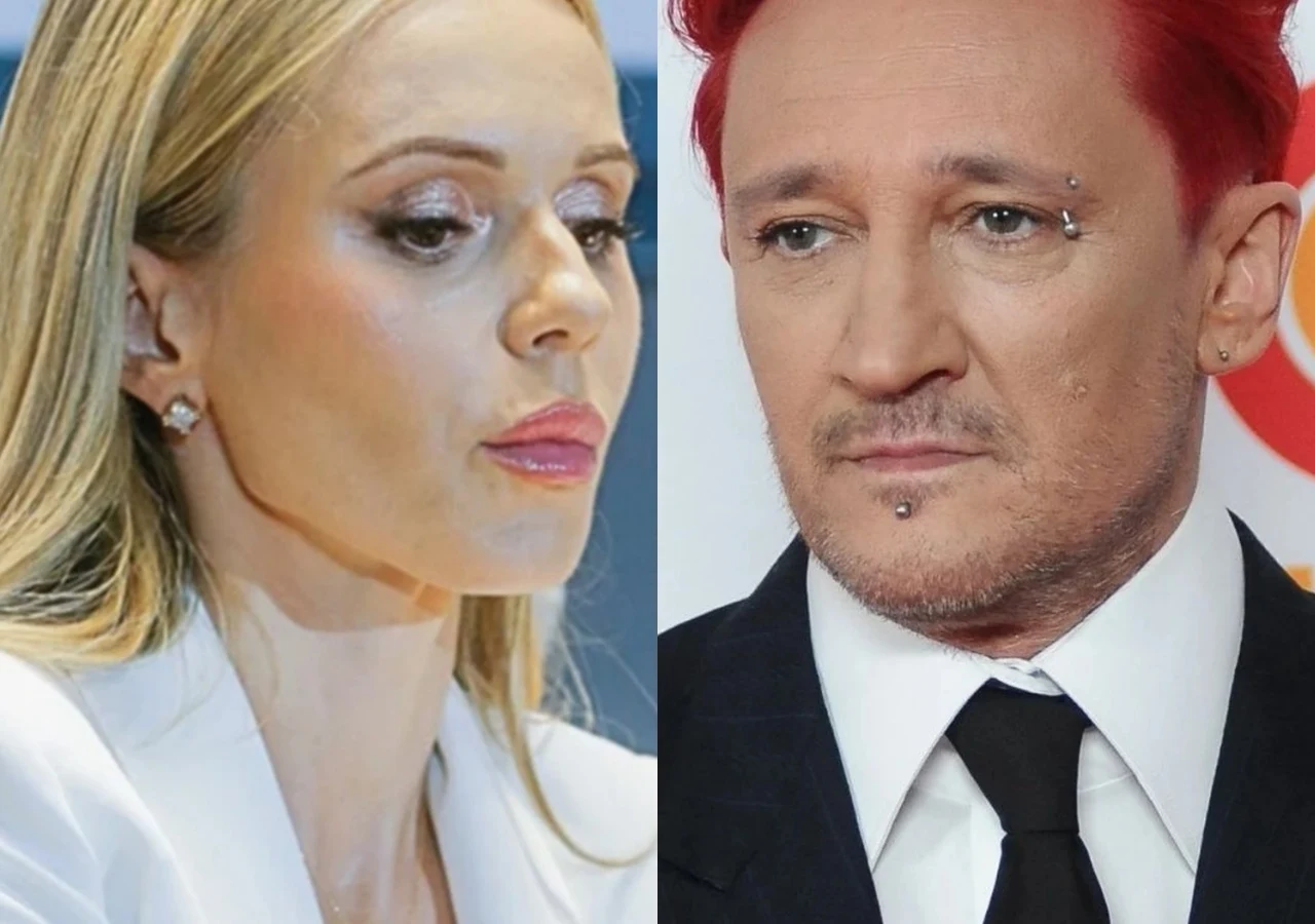 Doda, Michał Wiśniewski Portret dwóch osób, kobieta o blond włosach w białym stroju patrzy w dół z poważnym wyrazem twarzy, obok mężczyzna z czerwonymi włosami w garniturze, lekko zamyślony, tło neutralne, brak dodatkowych elementów.