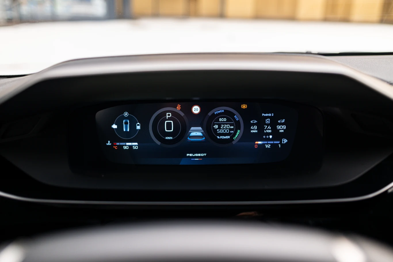 Cyfrowy wyświetlacz samochodowy ukazujący wskaźniki takie jak poziom paliwa, prędkość, przebieg, temperatura czy aktualny bieg oraz ostrzeżenia o stanie pojazdu.