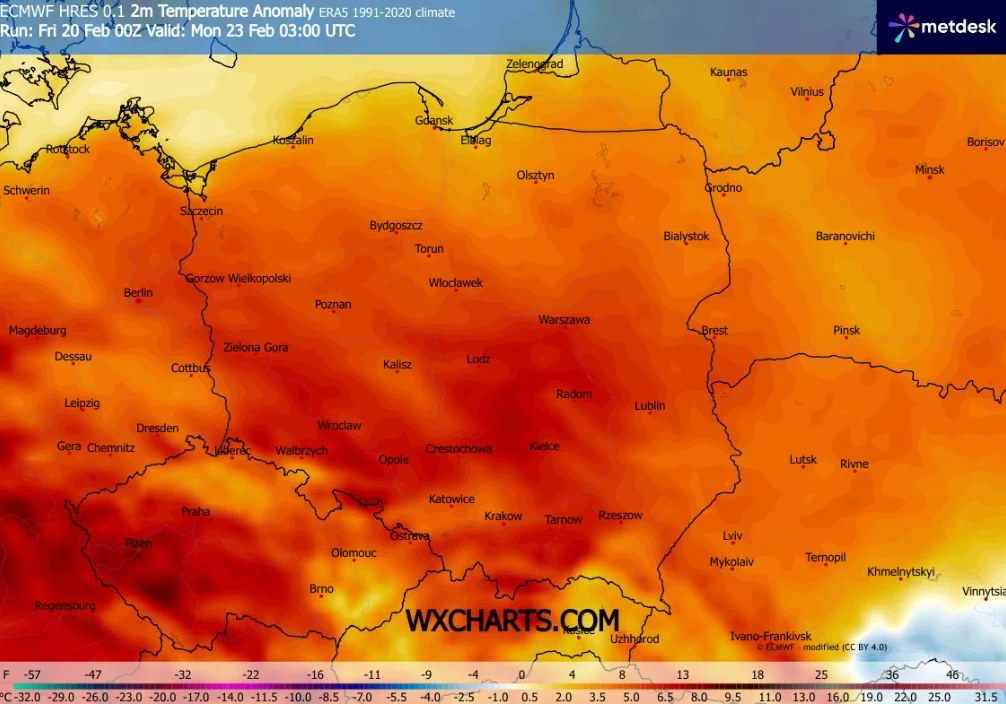 Kolorowa mapa Polski ukazująca anomalię temperatury powietrza na poziomie 2 metrów nad ziemią, z wyraźnymi różnicami temperatury pomiędzy regionami, oznaczeniami największych miast oraz legendą barwną w dolnej części.