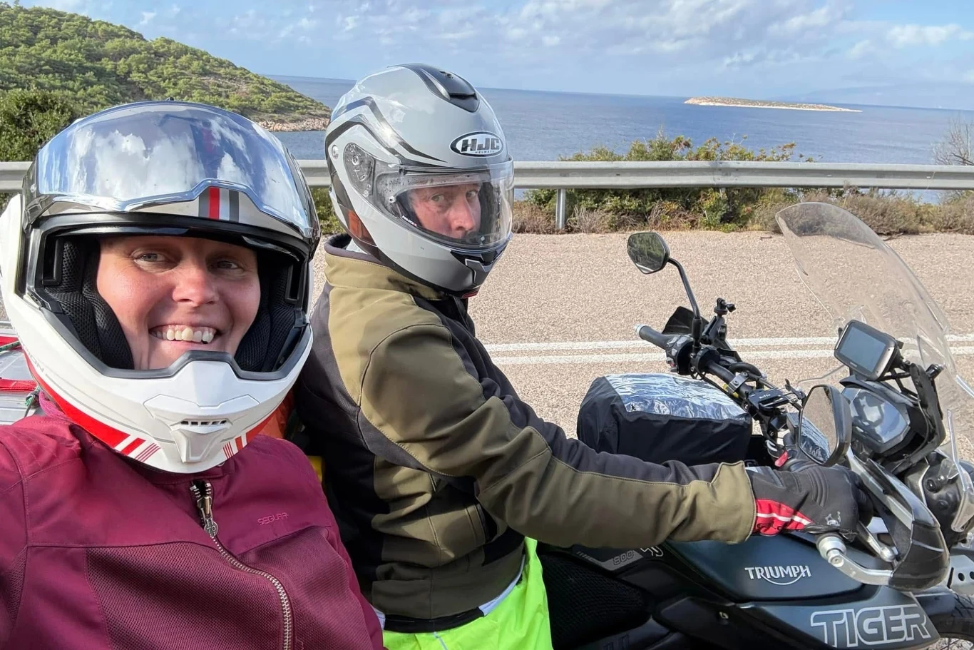 Para została skazana na 10 lat więzienia. / FB. Lindsay Foreman Dwie osoby w kaskach motocyklowych pozują do selfie na tle morza, lasu i zakrętu drogi, siedząc na motocyklu marki Triumph Tiger.