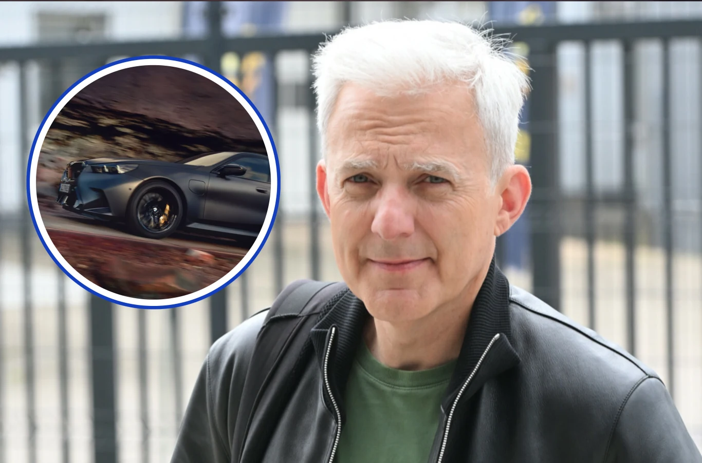 Czym jeździ Hubert Urbański? Mężczyzna o siwych włosach ubrany w czarną skórzaną kurtkę stoi na zewnątrz, w tle widać metalowe ogrodzenie. W lewym górnym rogu nałożone jest okrągłe zdjęcie samochodu sportowego jadącego z dużą prędkością po drodze.