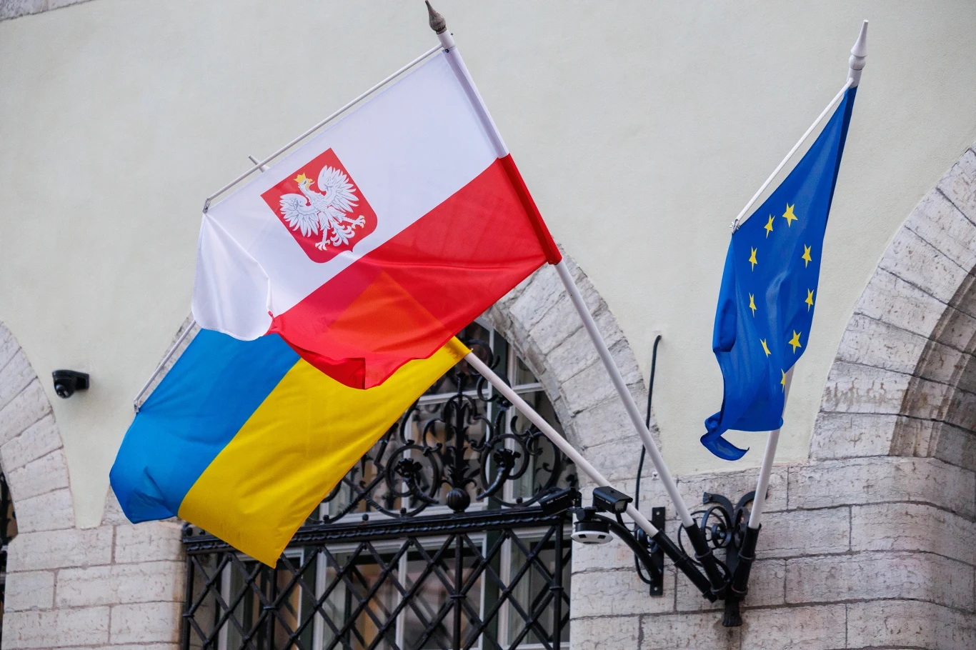 Ukraińcy skarżą się na opieszałość Polaków w kwestii wydawania pozwoleń na ekshumacje. Flagi wiszące na froncie budynku - widoczna od lewej flaga Ukrainy, Polski oraz Unii Europejskiej.