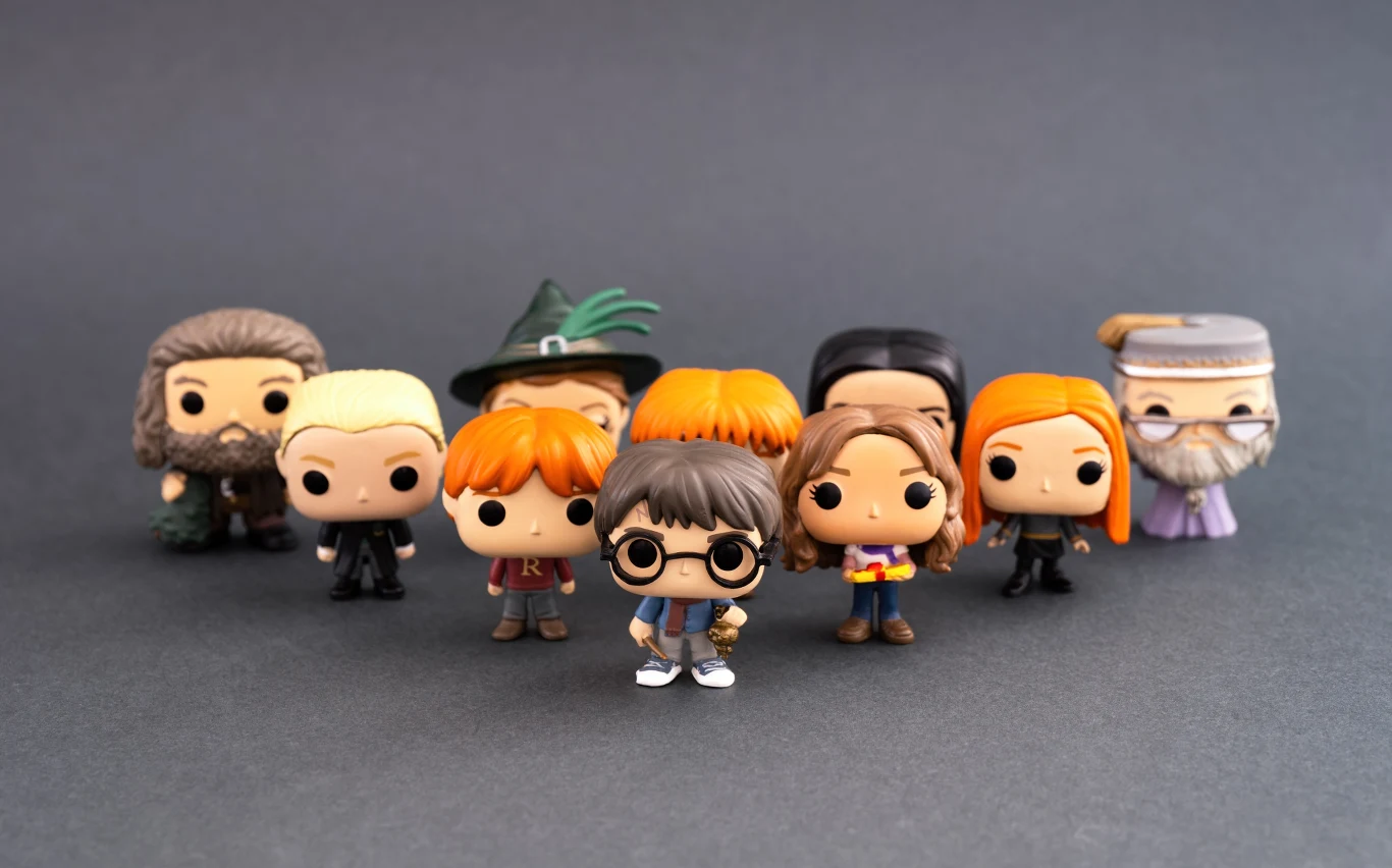 Grupa figurek kolekcjonerskich przedstawiających postacie z serii Harry Potter ustawiona na ciemnym tle, kolorowe miniatury postaci ustawione w dwóch rzędach.