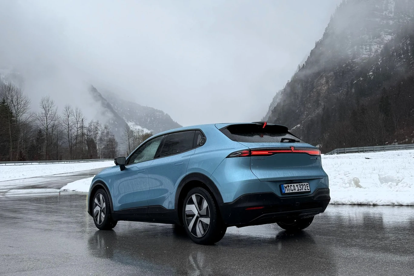 Changan Deepal S05 to elektryczny SUV segmentu C z deklarowanym zasięgiem do 485 km. Niebieski samochód elektryczny SUV zaparkowany na mokrej drodze, otoczony śniegiem, z górskim krajobrazem w tle.