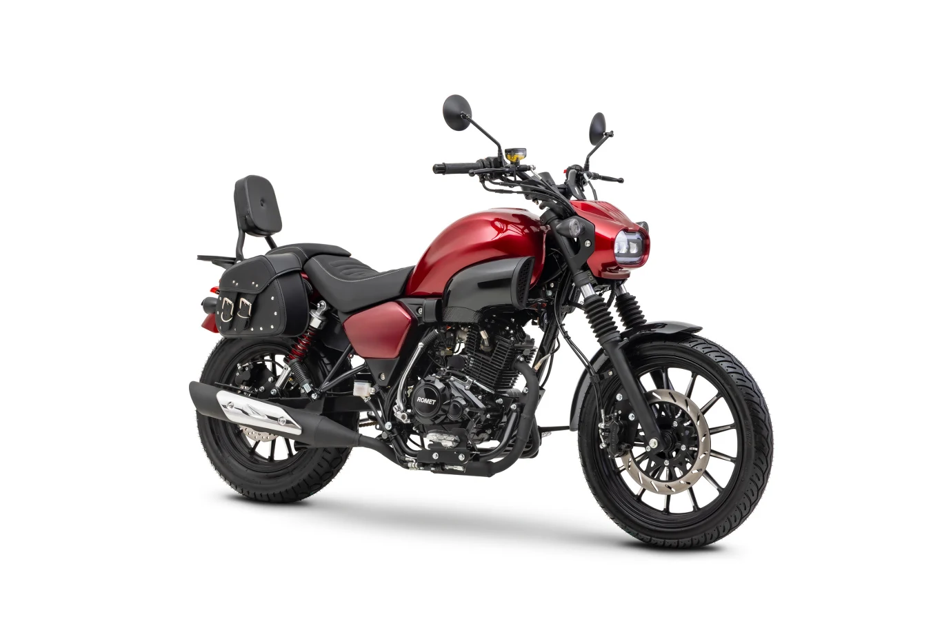 Motocykl w stylu cruiser o czerwonym metalizowanym lakierze, z czarnymi detalami, lustrami i bocznymi sakwami, wyposażony w wygodne siedzisko z oparciem dla pasażera oraz wyraźnie widocznym układem wydechowym.