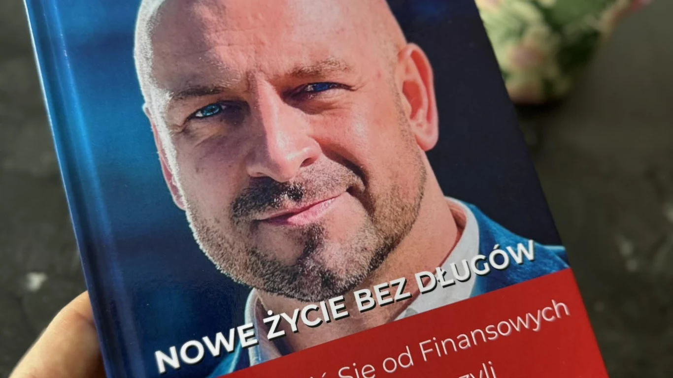 Okładka książki z widoczną twarzą łysiejącego mężczyzny z brodą na niebiesko-czerwonym tle, a nad nim widoczny tytuł 'Nowe życie bez długów' oraz fragment tekstu dotyczący finansowej wolności.