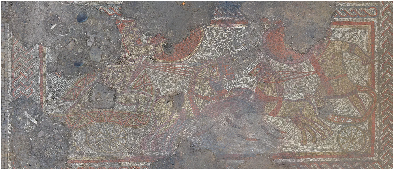 Starannie wykonana mozaika przedstawia scenę dwóch rydwanów zaprzężonych w konie, na których znajdują się woźnice, całość otoczona geometrycznym wzorem.